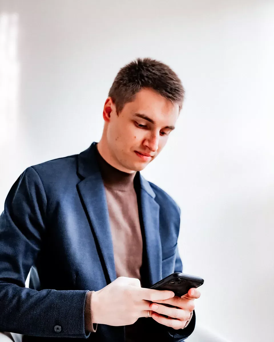 Artem si v štúdiu prezerá Instagram klienta na telefóne